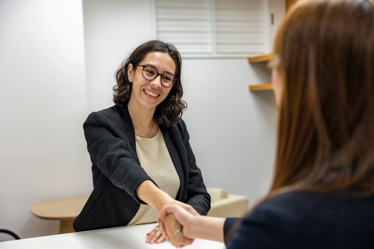The Art of Drawing Readers In: Your attractive post title goes here Businesswomen shaking hands in an office, representing a successful job interview or partnership.