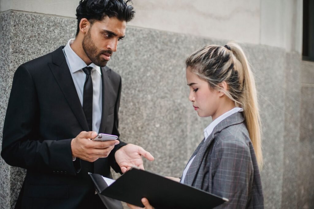 Two business professionals engaging in a serious conversation outside a building.