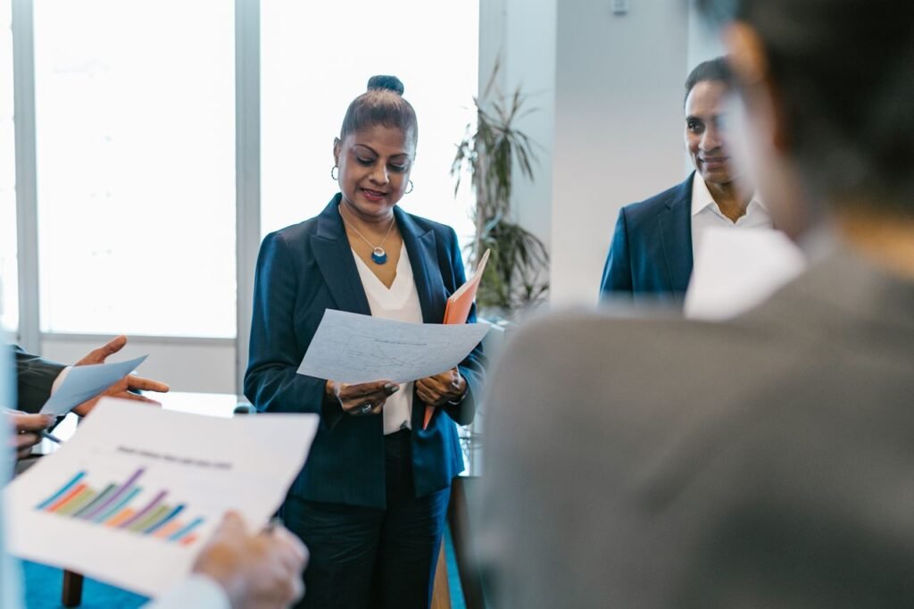A group of professionals reviewing documents during a business meeting in a modern office setting.