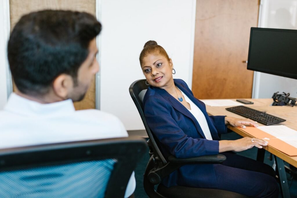 Two colleagues engaged in conversation, showcasing communication in a modern office.
